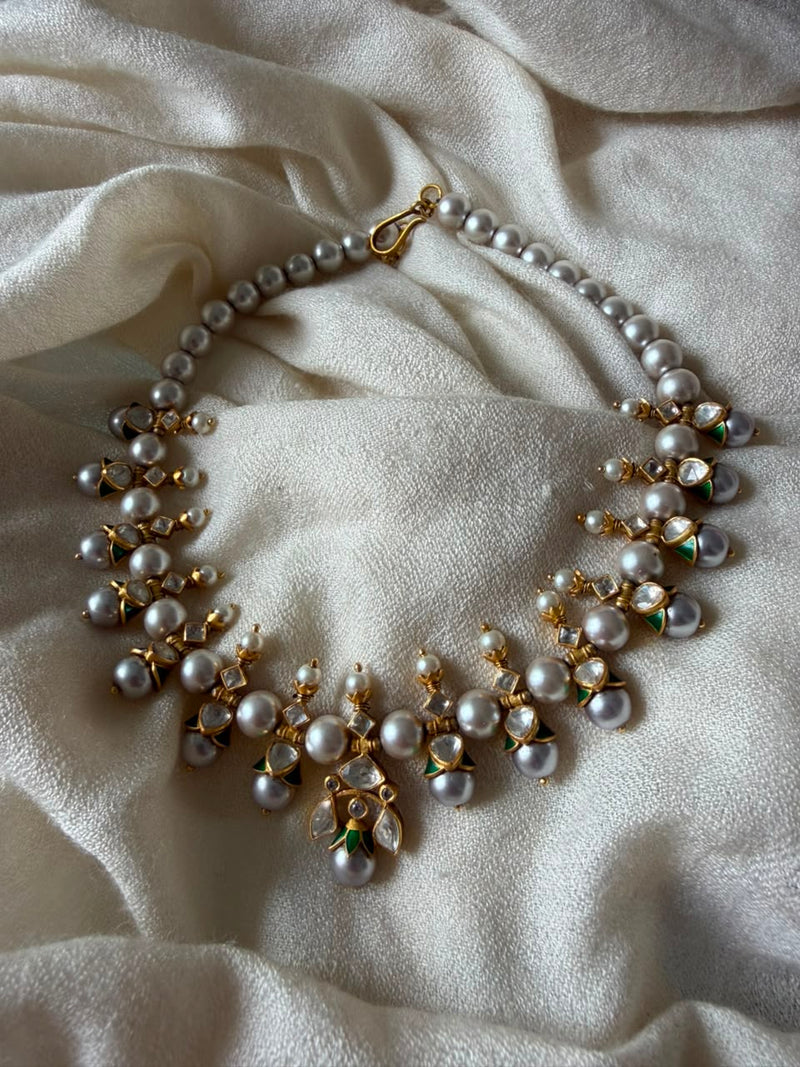 Handcrafted gold-plated Kundan choker necklace featuring cascading pearl drops and green Meenakari enamel details.