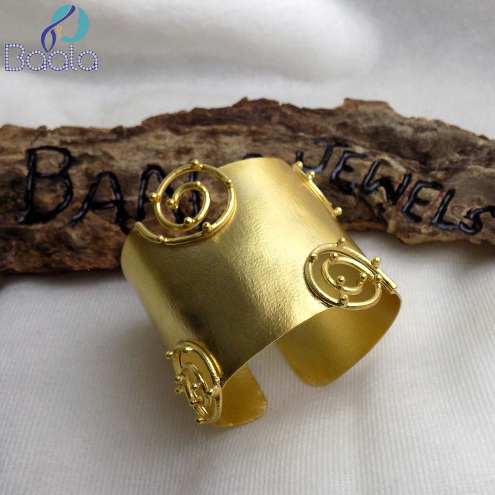 Gold-plated seashell loop cuff bracelet worn with a white halter top by Baala Jewels