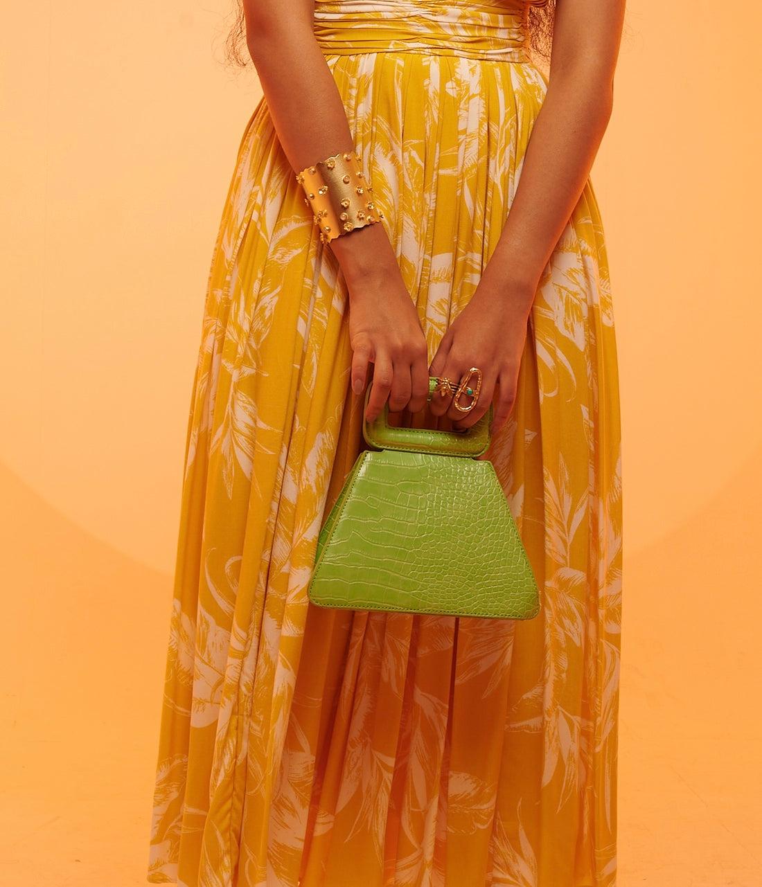 a person wearing oval turquoise stone ring along with yellow skirt outfit